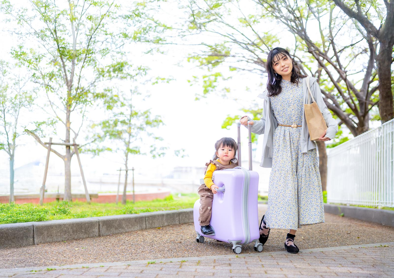スーツケースのそばにいる女性と子ども