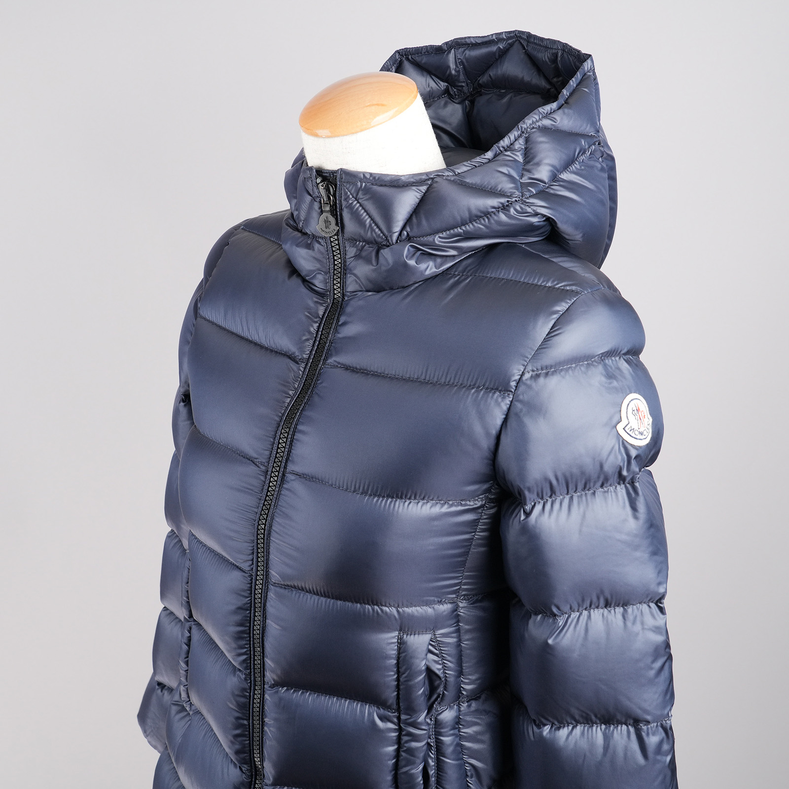 モンクレール（MONCLER）SUYEN フード付きダウンコート キッズ・レディース向け 140cm ネイビー｜上半身と左袖ロゴ